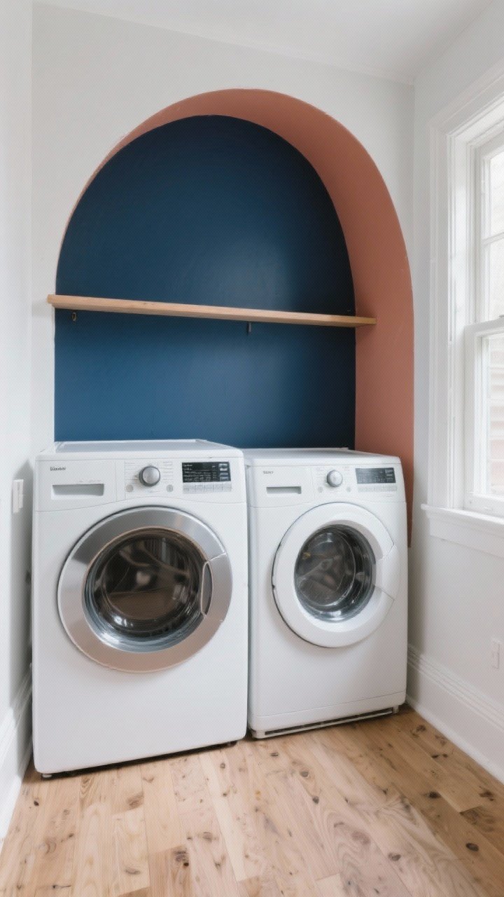 Photorealistic wide shot of a small laundry room with a single bold accent wall painted deep navy in semi-gloss, contrasted against crisp white front-loading washer and dryer; clean white trim, light oak flooring, and soft natural light from a side window; optional painted arch color block in a muted terracotta behind a simple floating shelf; the rest of the walls white, mood chic and high-contrast, no people.